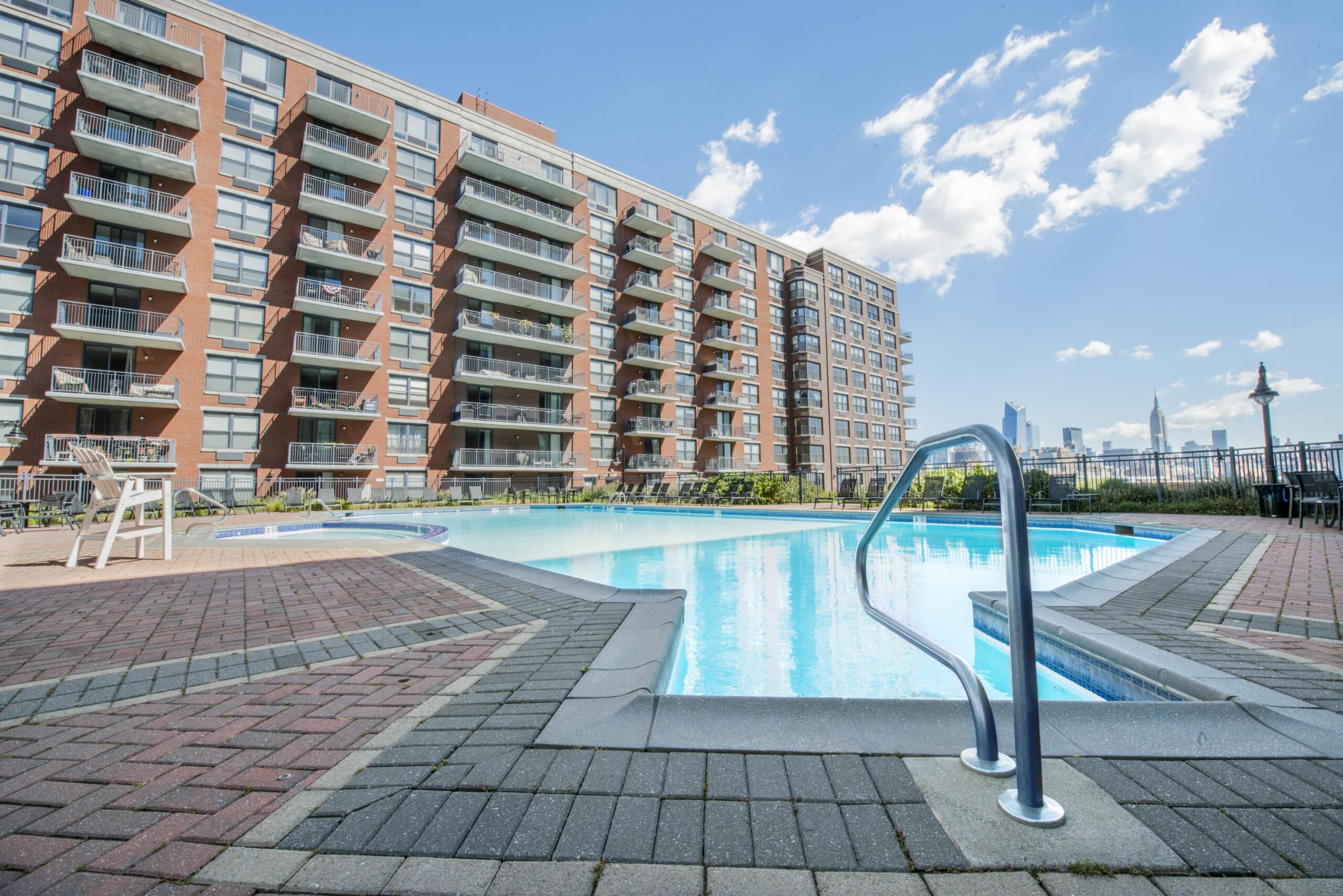 A pool with a brick apartment building in the back