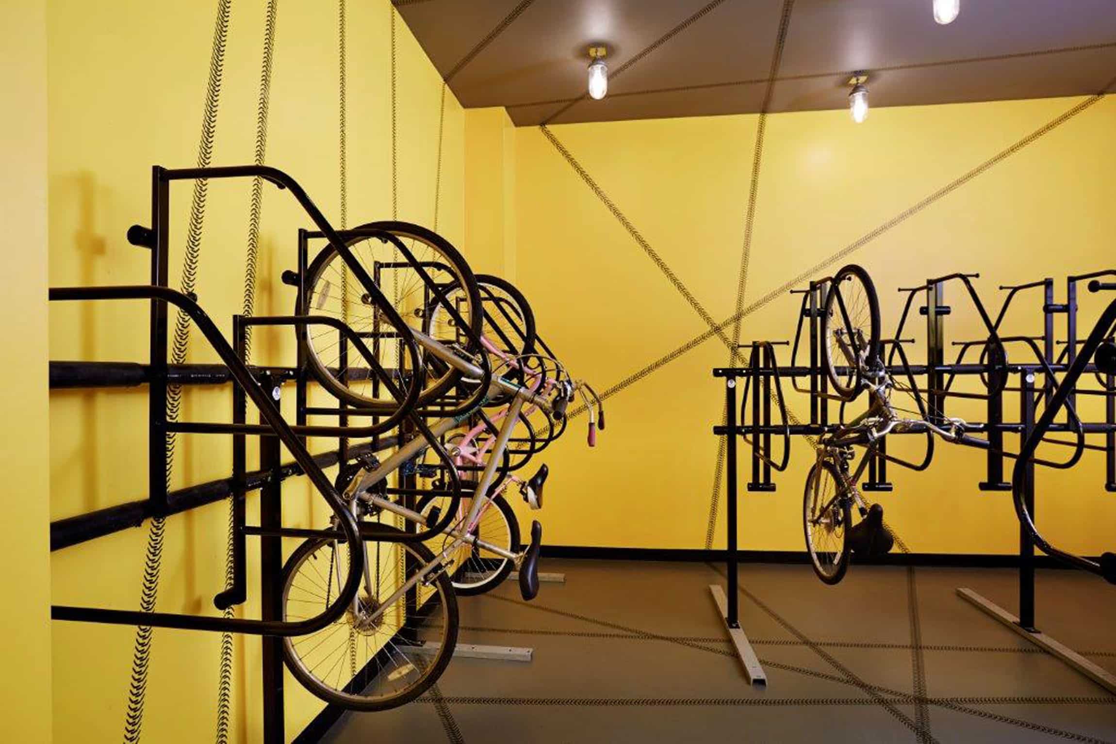 Bike rack room with yellow walls and bikes hanging up